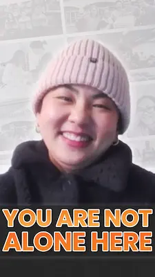 Person in winter jacket and pink beanie with text “You are not alone here”